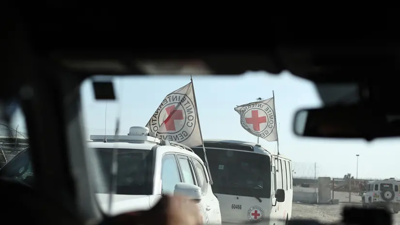epa12275629 A photo taken while embedded with the Israeli Army shows Red Cross workers waiting on the Palestinian side of the Kerem Shalom border crossing, between the Gaza Strip and Israel, 31 July 2025. EPA/ATEF SAFADI