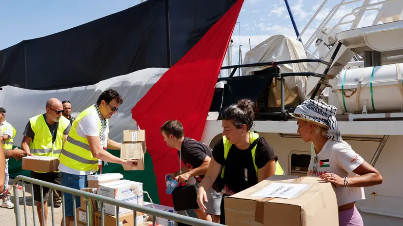 epa12339570 Volunteers load aid packages onto the ships of Flotilla Global Sumud before the departure at the port in Barcelona, northeastern Spain, 31 August 2025. The Flotilla Global Sumud will depart from Barcelona to Gaza on 31 August in a humanitarian action in support of the Palestinian people. EPA/TONI ALBIR