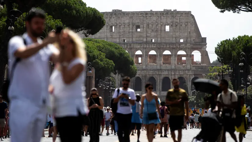Turisti passeggiano al Colosseo, Roma, 06 agosto 2023. ANSA/ANGELO CARCONI