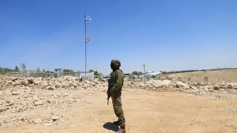 epa12275315 An Israeli soldier stands guard in Khirbet Umm Al-Khair, Hebron governorate, West Bank, 31 July 2025. According to the Palestinian Ministry of Health, Palestinian teacher and human rights activist Odeh Al-Hathalin, 31, succumbed to his wounds after being shot on 28 July by an Israeli settler while reportedly trying to prevent the bulldozing of Palestinian lands in the village. EPA/ALAA BADARNEH
