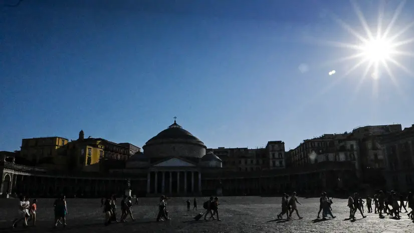 Turisti attraversano un'assolata piazza del Plebiscito, Napoli, 02 luglio 2025. ANSA / CIRO FUSCO