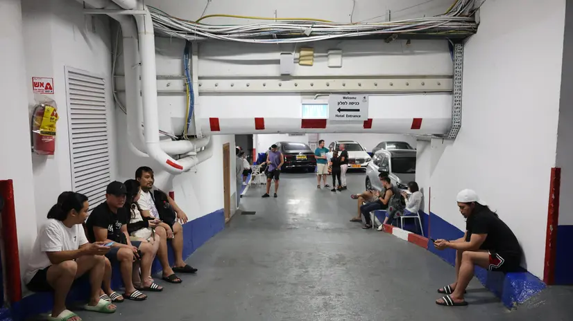 epa12184527 People take shelter in an hotel parking lot as sirens sound in response to Iranian ballistic missiles, in Tel Aviv, Israel, 18 June 2025. Israel and Iran have been exchanging fire since Israel attacked Iran on 13 June 2025 as part of operation 'Rising Lion'. EPA/ABIR SULTAN EPA
