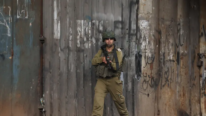 epa12326354 An Israeli soldier takes position during an army operation in the West Bank old city of Nablus, 27 August 2025. According to the Palestinian Health Ministry, at least 30 Palestinians were wounded during the operation. According to the Palestinian news agency Wafa, Israeli forces imposed a siege on the Old City of Nablus during the operation, during which one Palestinian was detained, and several families were evicted from their homes. EPA/ALAA BADARNEH