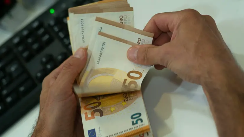 Un cassiere mentre conta banconote da 50 euro Danilo Schiavella/ANSA