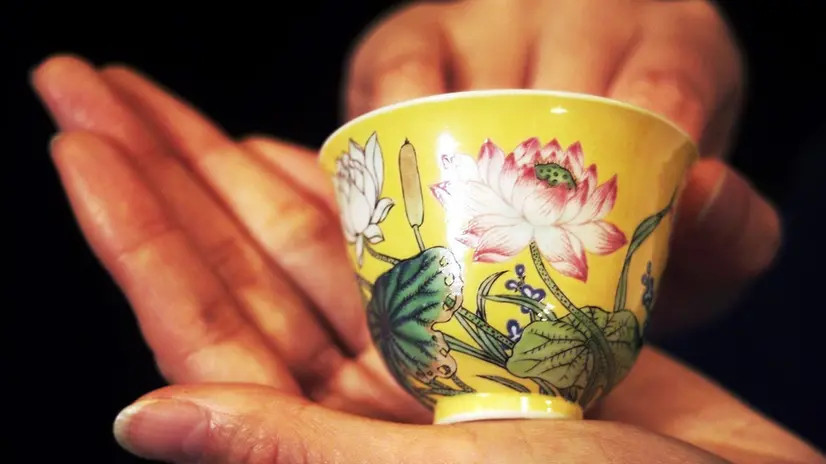 HKG04 - 19981103 - HONG KONG, CHINA : Christie's presents 03 November an extremely rare Imperial famille rose yellow-ground wine cup from the Qing Dynasty's Kangxi period (1662-1722), which generated considerable interest during Christie's Hong Kong's sale of Fine Chinese Ceramics and Works of Art, before being sold to a London dealer, Eskenazi for HK$6.62 million (USD$854,200.00), a record price for a Qing Dynasty enamel wine cup. (ELECTRONIC IMAGE) EPA/AFP/MANUEL CENETA