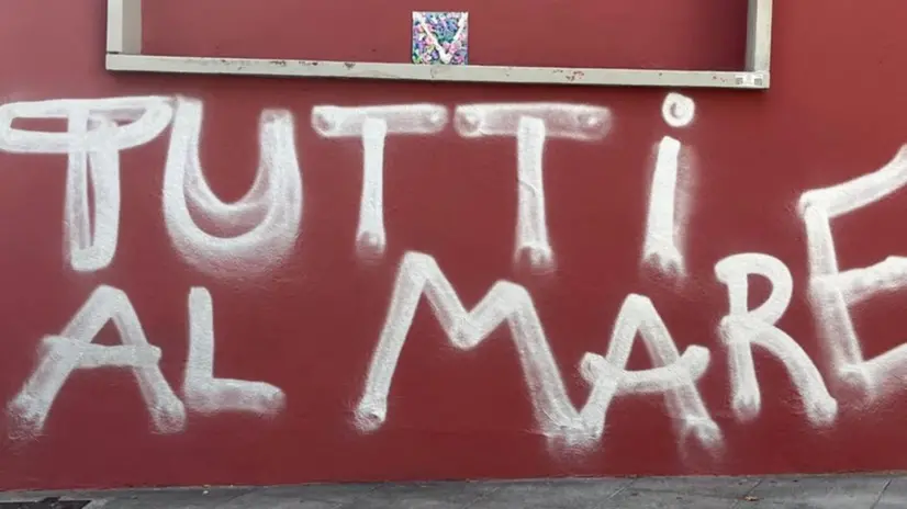 La scritta comparsa sulla parete esterna della scuola in via Nino Bixio