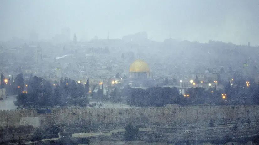 epa03528940 An overview of Jerusalem and it's Old City, including the distinctive golden Dome of the Rock, from the Mount of Olives, 09 January 2013 as a snow storm rolls into the city with waves of sleet, hail and high winds. Some 20cm of snow is expected overnight. EPA/JIM HOLLANDER