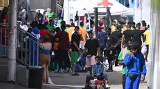 Alcuni dei 185 i migranti che sono sbarcati, dopo che i 4 barchini sui quali viaggiavano sono stati agganciati durante la notte dalle motovedette della guardia di finanza e della capitaneria, a Lampedusa, 19 settembre 2023. Ieri, sulla maggiore delle isole Pelagie, ci sono stati 7 sbarchi con un totale di 475 persone. ANSA / CIRO FUSCO Some of the 185 migrants who disembarked, after the 4 boats on which they were traveling, were docked during the night by the patrol boats of the Guardia di Finanza and the Captaincy, in Lampedusa, Italy, 19 September 2023. Yesterday, on the largest of the Pelagie Islands, there were 7 landings with a total of 475 people. ANSA / CIRO FUSCO