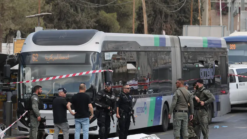 epaselect epa12361607 Israeli police officers gather near a body next to a bus as they work at the scene of a shooting incident in Jerusalem, 08 September 2025. At least five people were killed and several others injured by gunfire after a shooting incident at Ramot Junction in Jerusalem, according to Magen David Adom (MDA), Israel's national emergency services. EPA/ABIR SULTAN