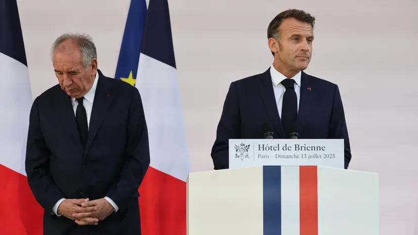 epa12236070 France Prime Minister Francois Bayrou (L) looks on as French President Emmanuel Macron (R) delivers a speech to army leaders on the eve of the annual Bastille Day Parade, at the l’Hotel de Brienne in Paris, France, 13 July 2025. EPA/LUDOVIC MARIN / POOL MAXPPP OUT