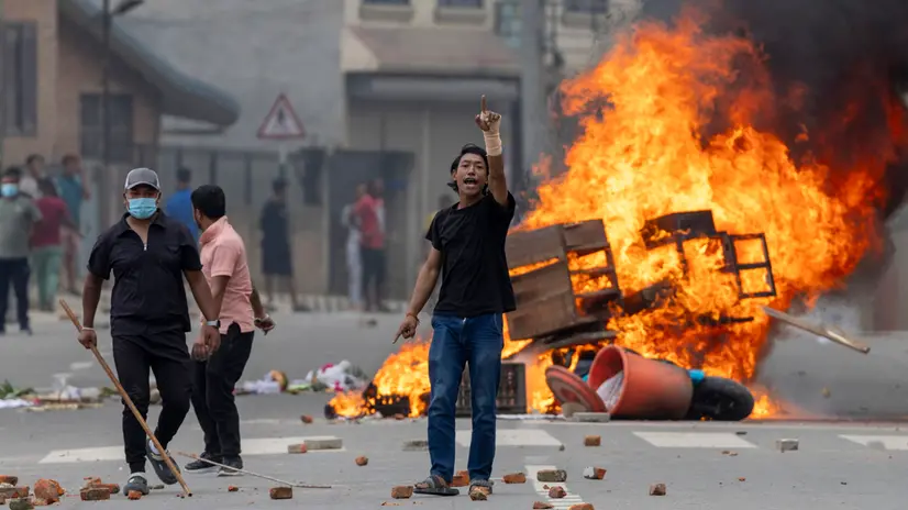 epa12363985 People stand near burning barricades during protests in Kathmandu, Nepal, 09 September 2025. At least 19 people were killed and dozens injured on 08 September during demonstrations against corruption and a government social media ban. EPA/NARENDRA SHRESTHA