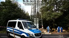 epa12365290 A police car is parked near workers inspecting a partially fire-damaged electricity pylon in Berlin, Germany, 09 September 2025. A fire at two high-voltage pylons in southeast Berlin caused a major power outage on 09 September morning, leaving more than 40,000 households and 3,000 businesses without electricity. Authorities suspect arson. EPA/FILIP SINGER