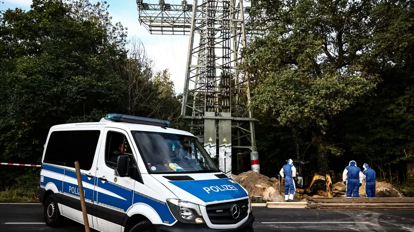 epa12365290 A police car is parked near workers inspecting a partially fire-damaged electricity pylon in Berlin, Germany, 09 September 2025. A fire at two high-voltage pylons in southeast Berlin caused a major power outage on 09 September morning, leaving more than 40,000 households and 3,000 businesses without electricity. Authorities suspect arson. EPA/FILIP SINGER