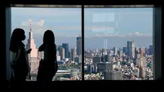 epa10179417 People look at the skyline from the 54th floor viewing deck of the Tokyo Metropolitan Government Building in Tokyo, Japan, 12 September 2022. Japan raised its daily entry cap on international arrivals from 20,000 to 50,000 on 07 September, as a part of an operation to ease COVID-19 travel restrictions that lasted over two years. EPA/KIMIMASA MAYAMA