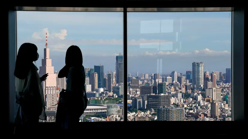 epa10179417 People look at the skyline from the 54th floor viewing deck of the Tokyo Metropolitan Government Building in Tokyo, Japan, 12 September 2022. Japan raised its daily entry cap on international arrivals from 20,000 to 50,000 on 07 September, as a part of an operation to ease COVID-19 travel restrictions that lasted over two years. EPA/KIMIMASA MAYAMA
