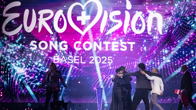 epa12111340 Austria's JJ and his delegation celebrate with the trophy of the winner of the 69th Eurovision Song Contest, with host Hazel Brugger, left, in Basel, Switzerland, 17 May 2025. EPA/GEORGIOS KEFALAS
