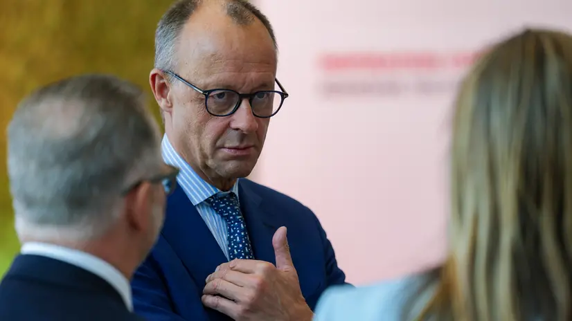 epa12373574 German Chancellor Friedrich Merz (C) during his visit at the Henkel AG factory in Duesseldorf, Germany, 13 September 2025. EPA/CHRISTOPHER NEUNDORF