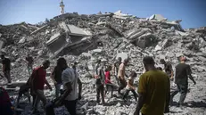 epa12380209 Palestinians inspect the rubble of the Al-Ghafari residential tower after it was hit by an Israeli airstrike in Gaza City, 15 September 2025. More than 64,900 Palestinians have been killed in the Gaza Strip since October 2023, according to the Palestinian Ministry of Health. EPA/HAITHAM IMAD