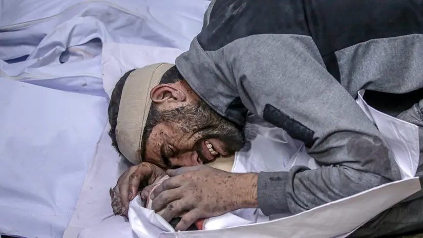 epa12238795 A Palestinian man mourns over the body of his dead child at the Al-Shifa hospital after an Israeli air strike in Gaza City, 15 July 2025. The Palestinian Ministry of Health in Gaza said that more than 30 Palestinians were killed following Israeli air strike over night and early in the day. EPA/MOHAMMED SABER