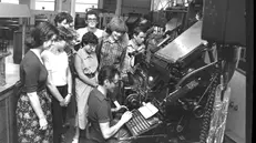 Un gruppo di studenti, in visita al Giornale di Brescia, davanti alla linotype negli anni Settanta © www.giornaledibrescia.it