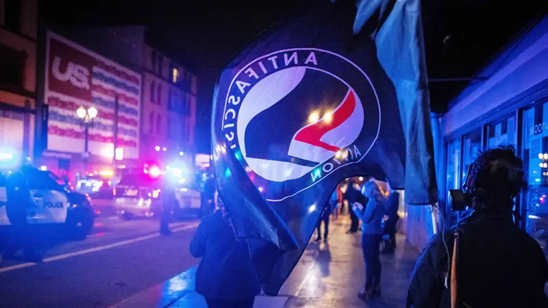 epa08799778 An Antifascist Action (Antifa) flag is seen during a protest following the US presidential election in Portland, Oregon, USA, 04 November 2020. Portland Police declared a riot after protesters began damaging businesses. EPA/CHRISTIAN MONTERROSA