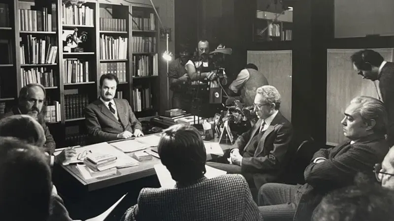 Riunione nello studio del direttore Gian Battista Lanzani (al centro con la barba): da sinistra si vedono i giornalisti Walter	Semeraro, vicedirettore, il capo della redazione politica Enzo Maizza, il responsabile della Cultura Attilio Mazza, e, di spalle, Claudio Baroni © www.giornaledibrescia.it