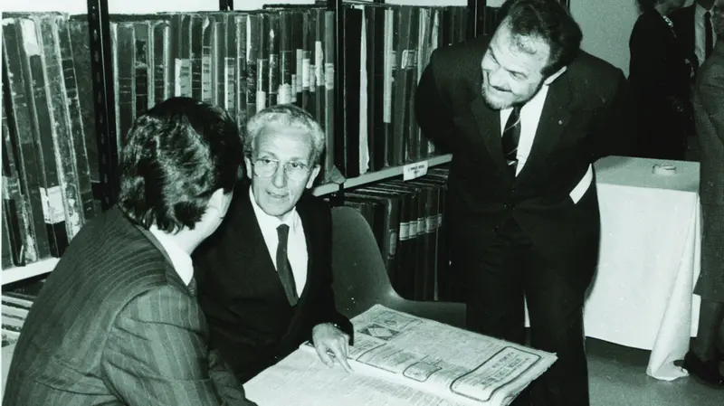 Il direttore Gian Battista Lanzani con l'avvocato Pompeo Anelli, del Cda dell'Editoriale bresciana, e di spalle l'on. Mino Martinazzoli sfogliano le raccolte del GdB il 12 maggio 1987 © www.giornaledibrescia.it