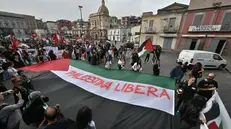 E' partito a Napoli da piazza Mercato il corteo di sostegno alla Palestina. Circa 500 le persone al momento partecipanti, anche originarie della Palestina e di altri paesi del medio oriente che vivono in città. Tante la bandiere palestinesi nel corteo aperto da uno striscione con la scritta "Non c'è pace sotto occupazione, Palestina libera". Metà del gruppo si è riunito in piazza Mercato e poi è stato raggiunto dall'altra metà, radunatasi in piazza Garibaldi, a ridosso della stazione ferroviaria. Il corteo si sta muovendo verso la prefettura dove verrà consegnato un documento dei manifestanti per il governo italiano, 20 ottobre 2023. ANSA/CIRO FUSCO