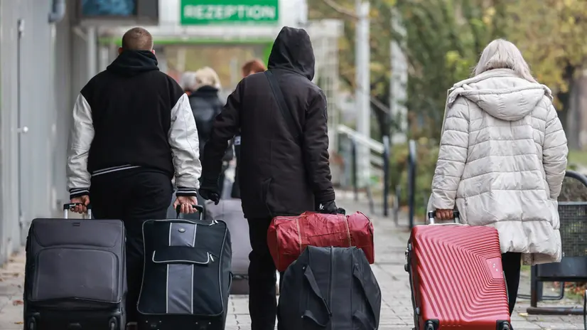 epa11714742 Migrants walk in front of the former Grand City Hotel Berlin at street Landsberger in Berlin, Germany, 11 November 2024. Refugees from the large accommodation center in Tegel moved into the Grand City Hotel. Several refugees are to be accommodated in the new center until the beginning of December. The refugees are asylum seekers from various countries as well as war refugees from Ukraine. EPA/HANNIBAL HANSCHKE