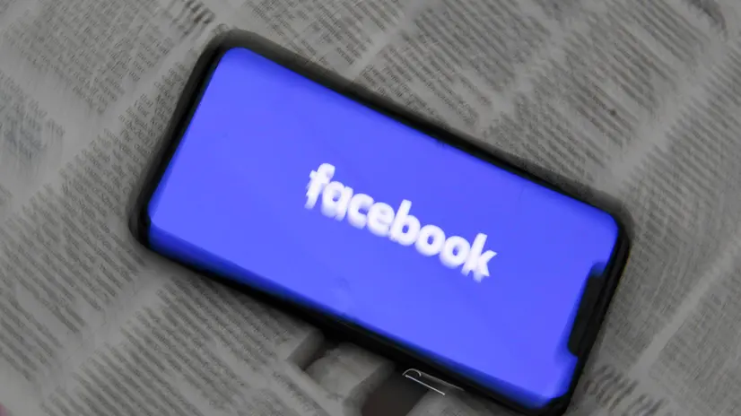 epa09020506 An illustration image shows a phone screen with the Facebook logo and Australian Newspapers at Parliament House in Canberra, Australia, 18 February 2021. Social media giant Facebook has moved to prohibit publishers and people in Australia from sharing or viewing Australian and international news content in response to Australia's proposed media bargaining laws. EPA/LUKAS COCH AUSTRALIA AND NEW ZEALAND OUT