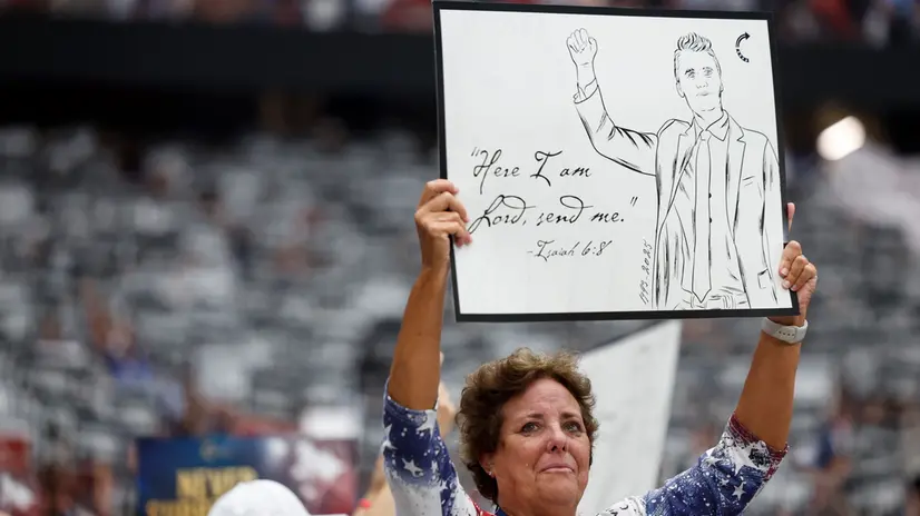 epa12396458 An attendee holds a placard during the public memorial service of political activist Charlie Kirk at State Farm Stadium in Glendale, Arizona, USA, 21 September 2025. Kirk was shot and killed on 10 September during a stop on his American Comeback Tour organized by Turning Point USA at Utah Valley University. EPA/CAROLINE BREHMAN