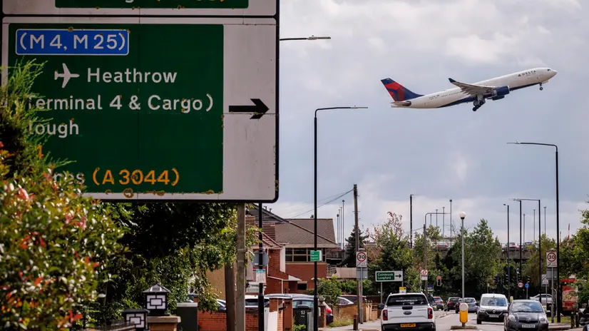 epa12277597 A Delta Air Lines flight takes off from Heathrow Airport, near a road sign for M4 and M25 motorways, behind houses and streets of Harmondsworth village, west London, Britain, 01 August 2025.The airport has submitted its plans to the British government for a new 3,500-metre long third runway, with an estimated cost of 21 billion GBP (24 bn EUR) to be built within a decade, which would also include a diversion of the M25 motorway. EPA/TOLGA AKMEN