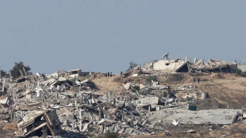 epa11836182 A group of Palestinians (C, rear) walks among the ruins of damaged buildings in the Gaza Strip, as seen from the Israeli-Gaza border in southern Israel, 19 January 2025, amid a ceasefire between Israel and Hamas. Israel and Hamas agreed on a hostage release deal and a Gaza ceasefire to be implemented on 19 January 2025. More than 46,000 Palestinians have been killed in the Gaza Strip, according to the Palestinian Ministry of Health, since Israel launched a military campaign in the strip in response to a cross-border attack led by the Palestinian militant group Hamas on 07 October 2023, in which about 1,200 Israelis were killed and more than 250 taken hostage. EPA/ABIR SULTAN