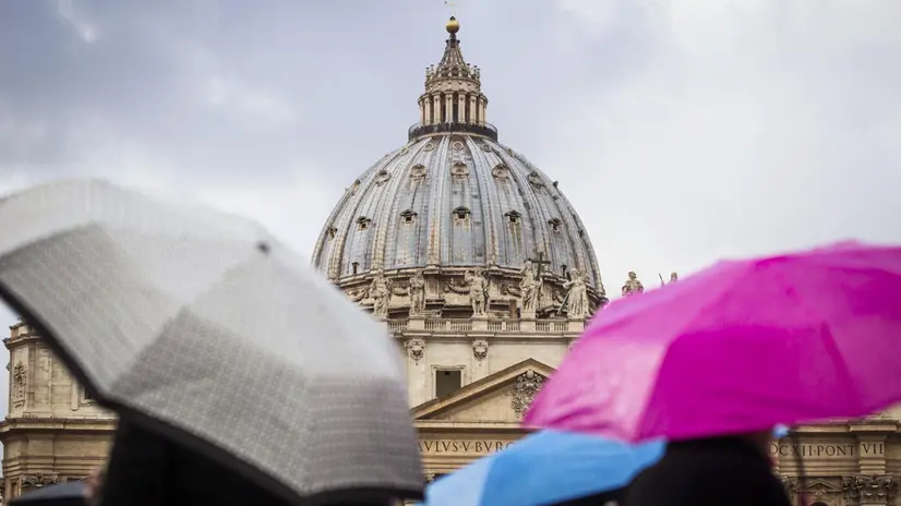 Turisti si riparano con degli ombrelli davanti San Pietro per il maltempo abbattutosi sulla Capitale, Roma, 05 gennaio 2014. ANSA/ANGELO CARCONI