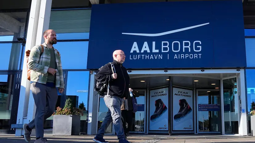 epa12403934 People walk in front of the entrance of Aalborg Airport, in Aalborg, Denmark, 25 September 2025. The airspace over Aalborg Airport was closed overnight after drones were observed over the airport, according to the police. The incident occurred days after drones were spotted near Copenhagen Airport on the evening of 22 September, forcing its closure for a few hours. EPA/BO AMSTRUP DENMARK OUT
