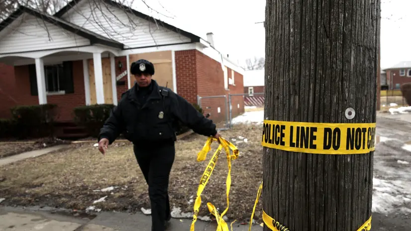 epa03614414 Detroit Police recycles crime scene tape on the street where three people were found shot to death in a home on Coyle Street on the west side of Detroit, Michigan USA on 07 March 2013. The Detroit Free Press reported that two children, ages 1 and 5, were found in the home unharmed according to police. The City of Detroit recorded 386 homicides in 2012. EPA/JEFF KOWALSKY