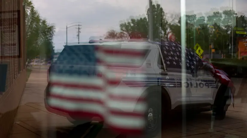 epa11311326 Flowers and an American flag on top of a police cruiser memorial is reflected in a window outside the Charlotte-Mecklenburg Police Departmentâ€™s North Tryon Division Headquarters in the aftermath of a shooting which left four law enforcement officers dead, in Charlotte, North Carolina, USA, 30 April 2024. Four law enforcement officers were killed and four others injured when members of the US Marshals Fugitive Task Force attempted to serve a warrant on Terry Clark Hughes Jr on 29 April 2024. Hughes was also killed in the incident according to the Charlotte-Mecklenburg Police Department. EPA/VEASEY CONWAY