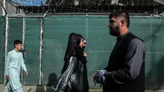 epa12304402 Afghans walk on a road as Taliban mark the fourth anniversary of Taliban takeover of Afghanistan, in Kabul, Afghanistan, 16 August 2025. Taliban supporters marked the fourth anniversary of the group's return to power with street marches, flag displays, and flower-spraying in Kabul, as regime symbols covered walls and a bustling market for Taliban flags emerged across the city. EPA/SAMIULLAH POPAL