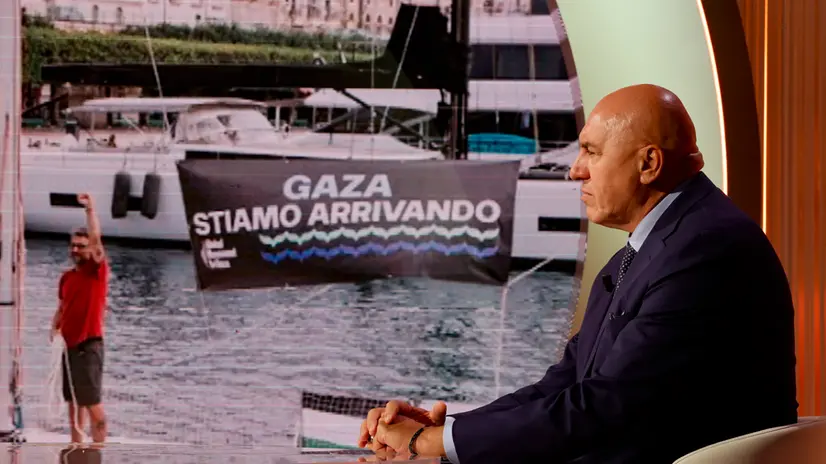 Il ministro della difesa Guido Crosetto e sullo sfondo una foto della Global Sumud Flotilla for Gaza, durante la trasmissione televisiva ‘’Cinque Minuti’’ in onda su Rai Uno, Roma 29 settembre 2025. ANSA/FABIO FRUSTACI