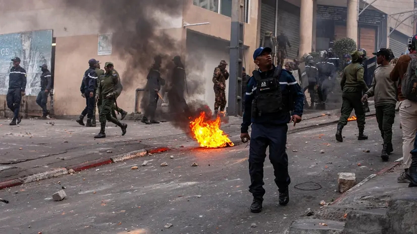 epa12405380 Members of the security forces walk past burning tires set on fire by protesters during a rally in Antananarivo, Madagascar, 25 September 2025. Police fired tear gas and rubber bullets to disperse hundreds of protesters demonstrating against recurrent water and power outages. EPA/HENITSOA RAFALIA