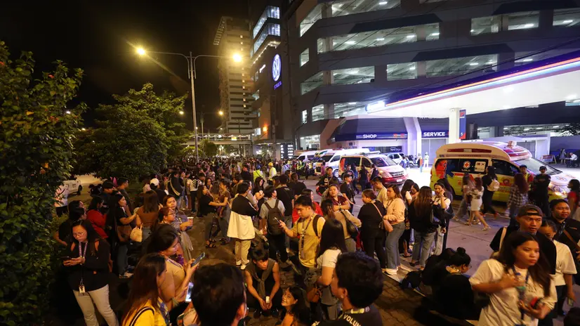 epa12418096 Filipino employees gather outside their office building after an earthquake in Ilo-Ilo city, Philippines, 30 September 2025. A magnitude 6.9 earthquake jolted Central Philippines according to the Philippine Institute of Volcanology and Seismology (Phivolcs). EPA/ARNOLD ALMACEN