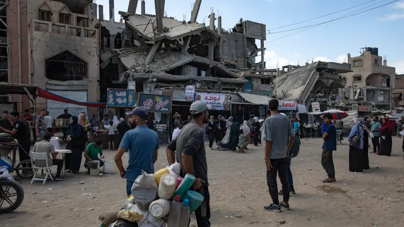 epa12416672 Internally displaced Palestinians walk past a destroyed building in Khan Younis, southern Gaza Strip, 30 September 2025. According to the UN around 90 per cent of the population or 1.9 million people in Gaza have been displaced since the start of the conflict. More than 66,000 Palestinians have been killed in the Gaza Strip since October 2023, according to the Palestinian Ministry of Health, and about 1,200 Israelis have been killed since the launch of an Israeli military campaign in response to a cross-border attack by Hamas on 07 October 2023. EPA/HAITHAM IMAD