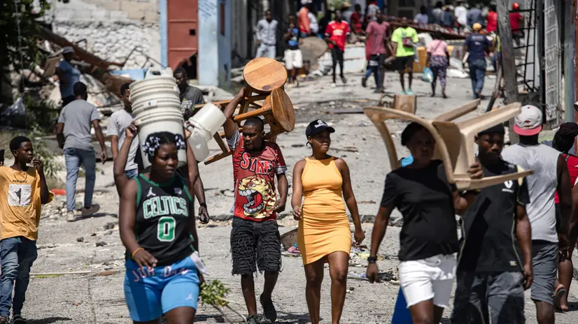 epa12328254 People walk through the Nazon neighborhood of Port-au-Prince, Haiti, 26 August 2025 (issued 27 August 2025). Hundreds of people displaced by violence from armed gangs in the Haitian capital are trying to return to their homes after gang leader Jimmy Cherisier, alias Barbecue, announced that residents could return following his order for his 'soldiers' to withdraw from certain areas. EPA/MENTOR DAVID LORENS