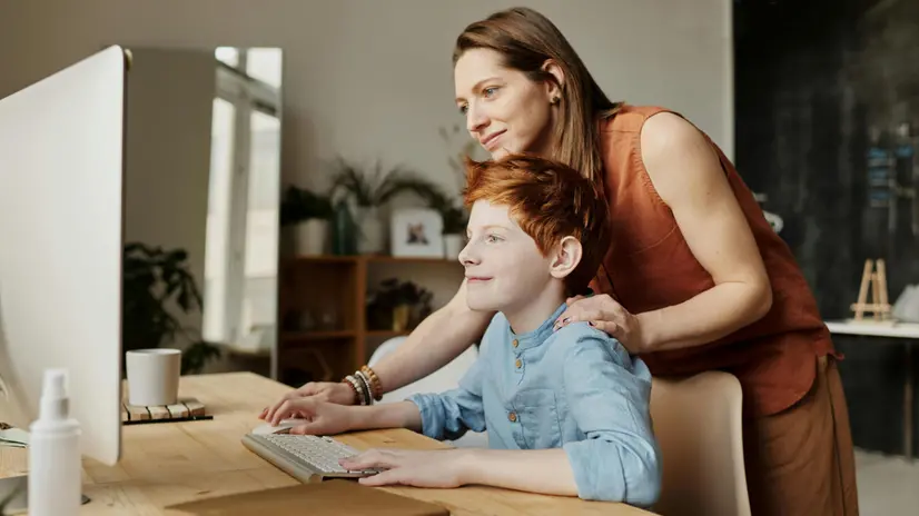 Una madre con il proprio figlio davanti a un computer