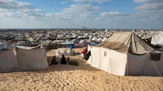 epa12415098 Displaced Palestinians from the northern Gaza Strip sit next to their tents in the Al-Mawasi area of Khan Younis, in the southern Gaza Strip, 25 September 2025. According to the UN, around 90 per cent of the population or 1.9 million people in Gaza, have been displaced since the start of the conflict. EPA/HAITHAM IMAD
