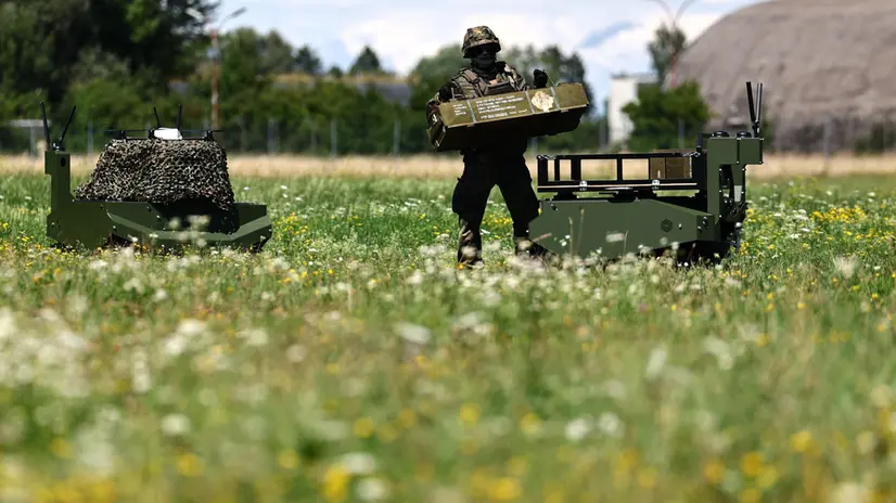 epa12253432 A soldier takes a box from a Gereon unmanned ground vehicle during the visit of the German defense minister at the Innovation Lab at the Bundeswehr Research Institute for Materials, Fuels and Lubricants (WIWeB) in Erding, Germany, 22 July 2025. WIWeB is an independent Bundeswehr research center focusing on the chemical, physical, and safety-related properties of materials, fuels, textiles, and chemicals. EPA/ANNA SZILAGYI