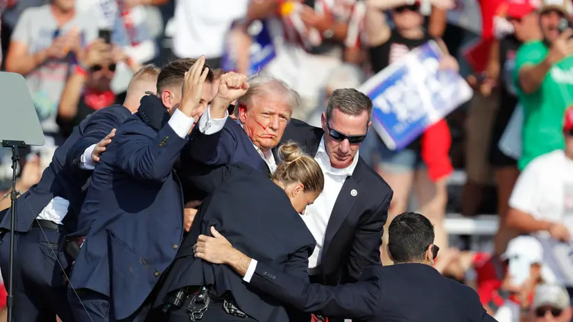 epa11476785 Former US President Donald Trump pumps his fist as he is rushed from stage by secret service after an incident during a campaign rally at the Butler Farm Show Inc. in Butler, Pennsylvania, USA, 13 July 2024. Trump was rushed off stage by secret service after an incident during a campaign rally in Pennsylvania. According to the Butler County district attorney a suspected gunman was dead and at least one rally attendee was killed. According to a statement by a secret service spokesperson, the former President is safe and further information on the incident will be released when available. EPA/DAVID MAXWELL