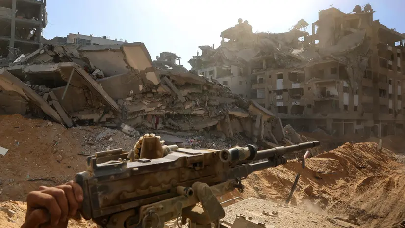 epa12430663 A photo taken while embedded with the Israeli Army and cleared by Israeli military censors shows an Israeli army soldier holding a mounted machine gun in front of destroyed buildings in the vicinity of the Jordanian Field Hospital in Gaza City, 03 October 2025 (issued 04 October 2025). Israel's military said on 04 October to advance readiness for the implementation of the first phase of the Trump plan for the release of the hostages while the same time make the safety of IDF troops a top priority and allocate all IDF capabilities to the Southern Command to ensure the protection of the troops. EPA/JACK GUEZ / POOL --PHOTO TAKEN DURING A CONTROLLED TOUR AND SUBSEQUENTLY EDITED UNDER THE SUPERVISION OF THE ISRAELI MILITARY--