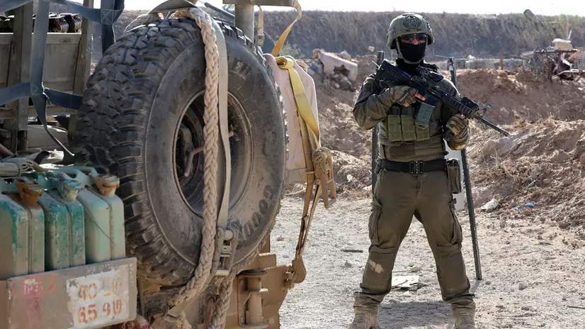 epa12430661 A photo taken while embedded with the Israeli Army and cleared by Israeli military censors shows an Israeli army soldier standing next to a military jeep in Gaza City, 03 October 2025 (issued 04 October 2025). Israel's military said on 04 October to advance readiness for the implementation of the first phase of the Trump plan for the release of the hostages while the same time make the safety of IDF troops a top priority and allocate all IDF capabilities to the Southern Command to ensure the protection of the troops. EPA/JACK GUEZ / POOL --PHOTO TAKEN DURING A CONTROLLED TOUR AND SUBSEQUENTLY EDITED UNDER THE SUPERVISION OF THE ISRAELI MILITARY--
