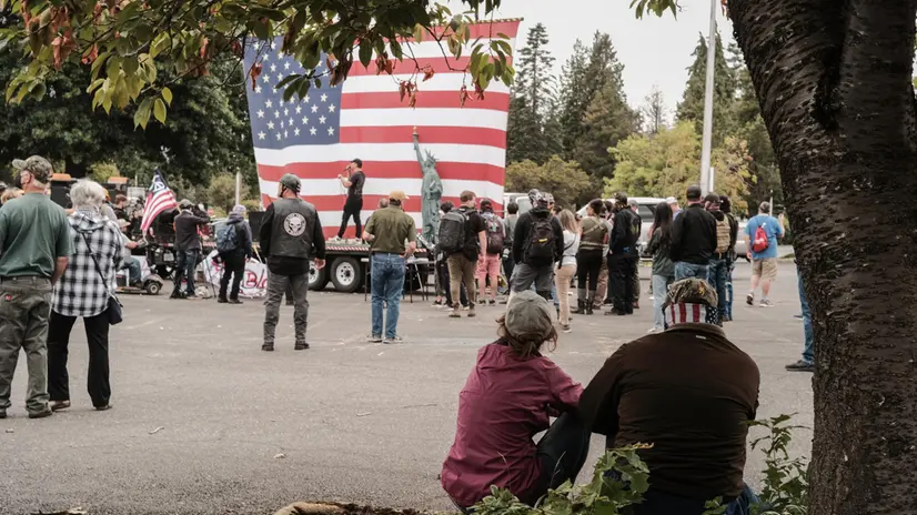 epa09425678 A couple takes in the scene at the Far Right rally in Portland, Oregon, USA, 22 August 2021. EPA/DANIEL STEINLE